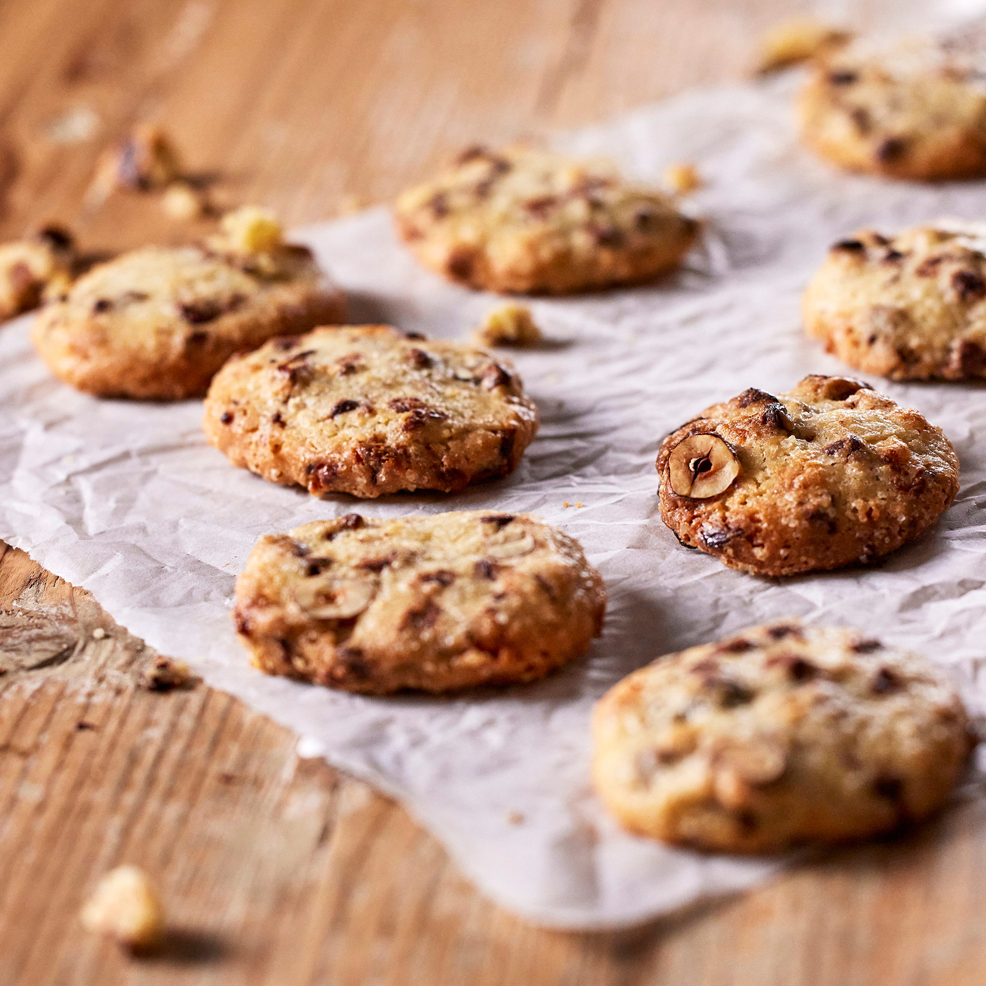 Cookies aux pépites de chocolat et noisettes refroidissant sur un papier cuisson