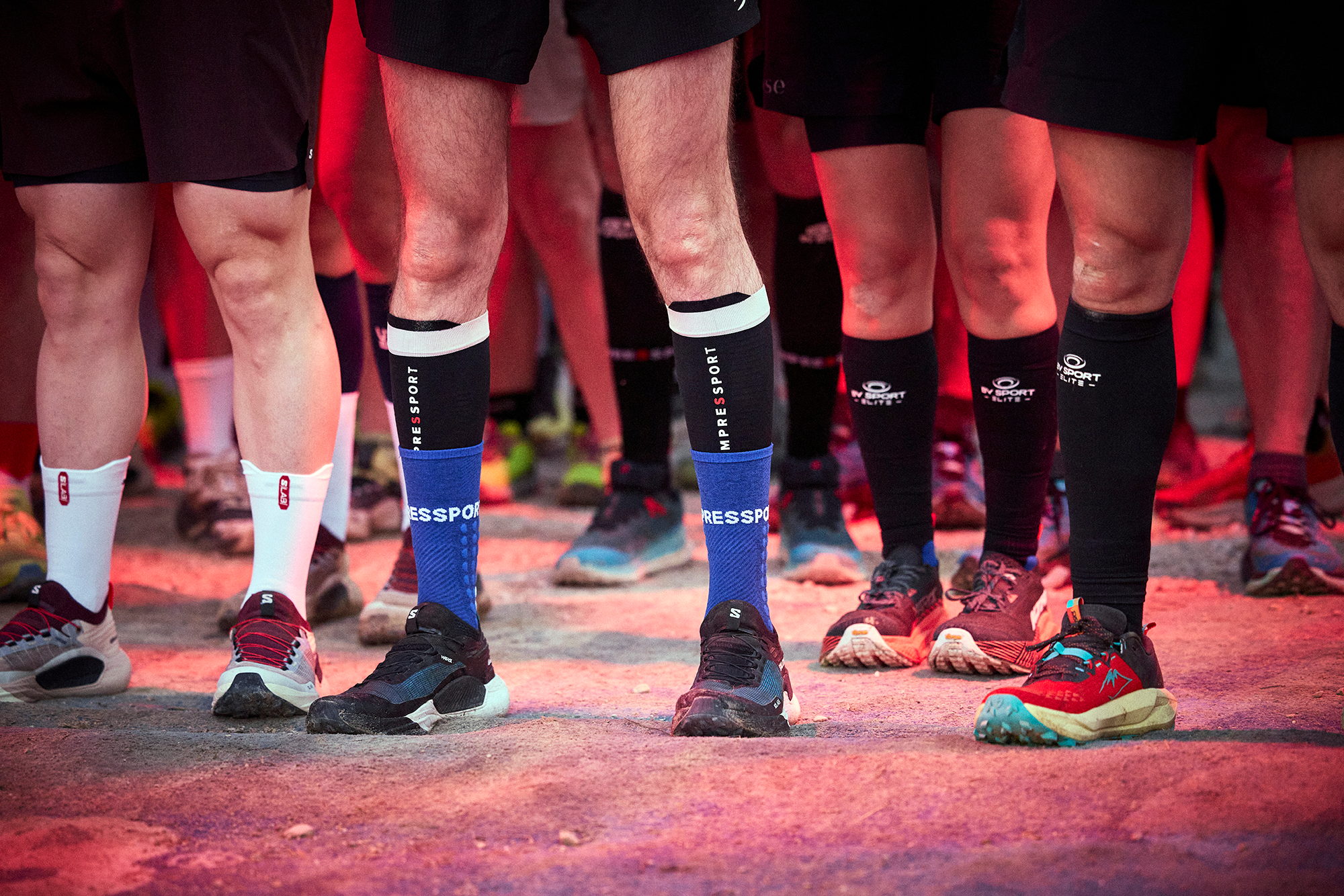 Jambes et chaussures de trail alignées sur le tapis de départ