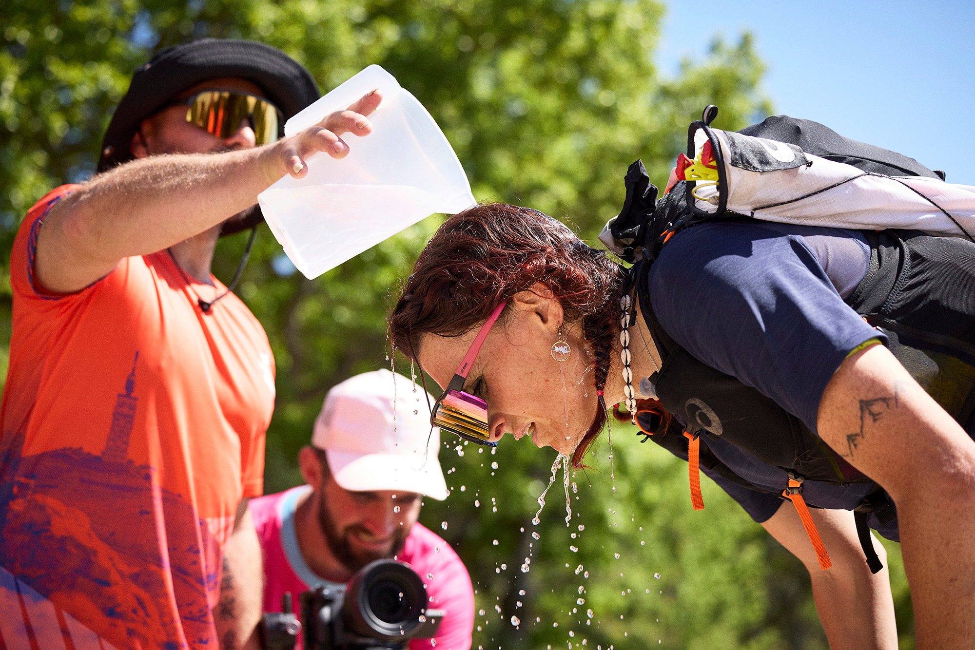 Coureur s'aspergeant le visage d'eau à un poste de ravitaillement