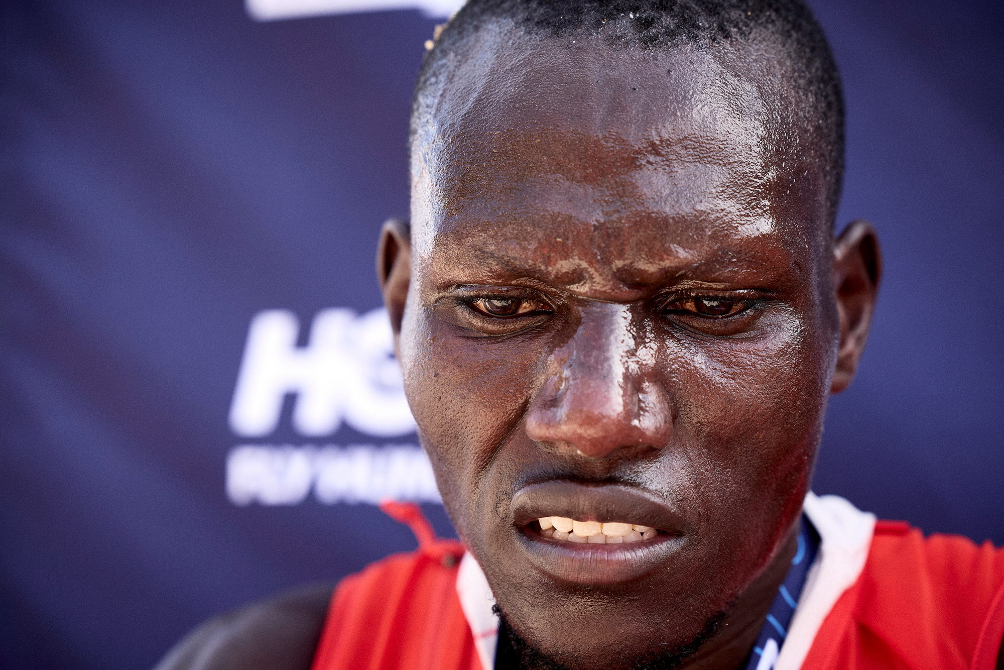 Portrait serré d'un coureur en sueur, regard droit, après la course