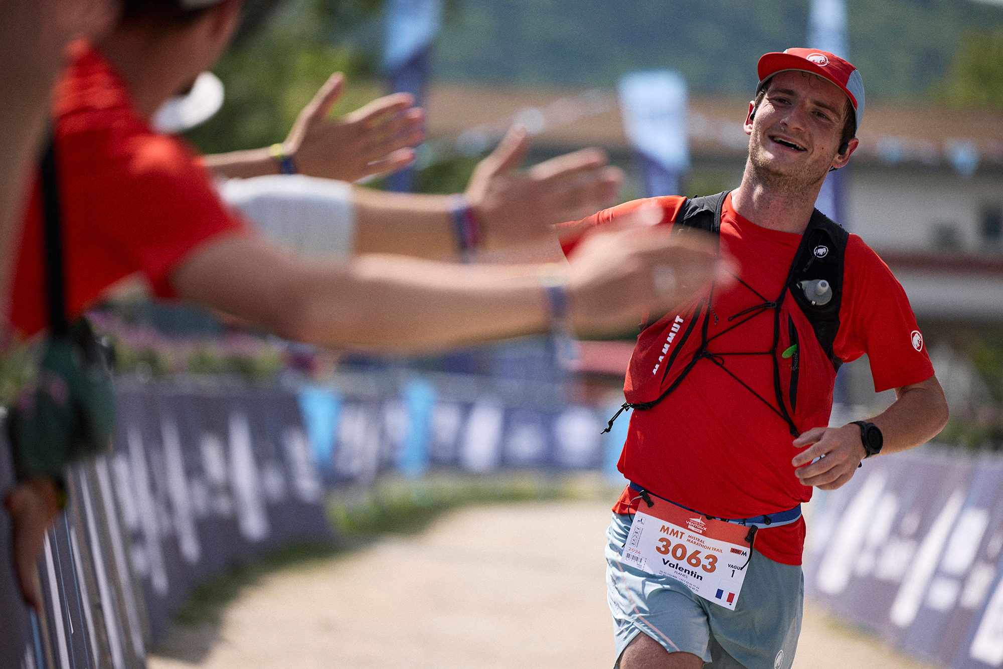 Coureur tapant dans les mains du public le long des barrières