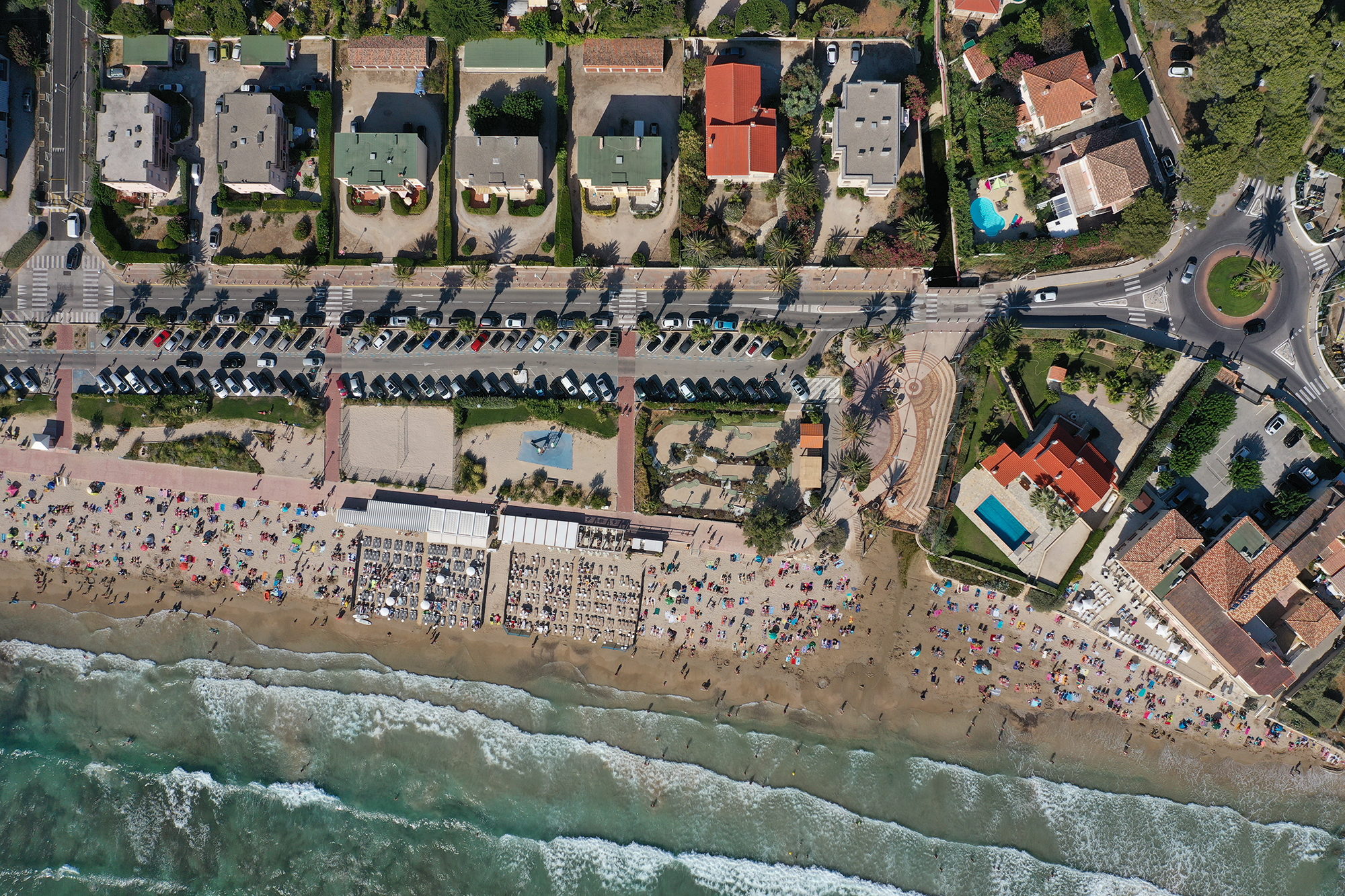 Vue aérienne d'un bord de mer urbanisé, plage et toitures alignées